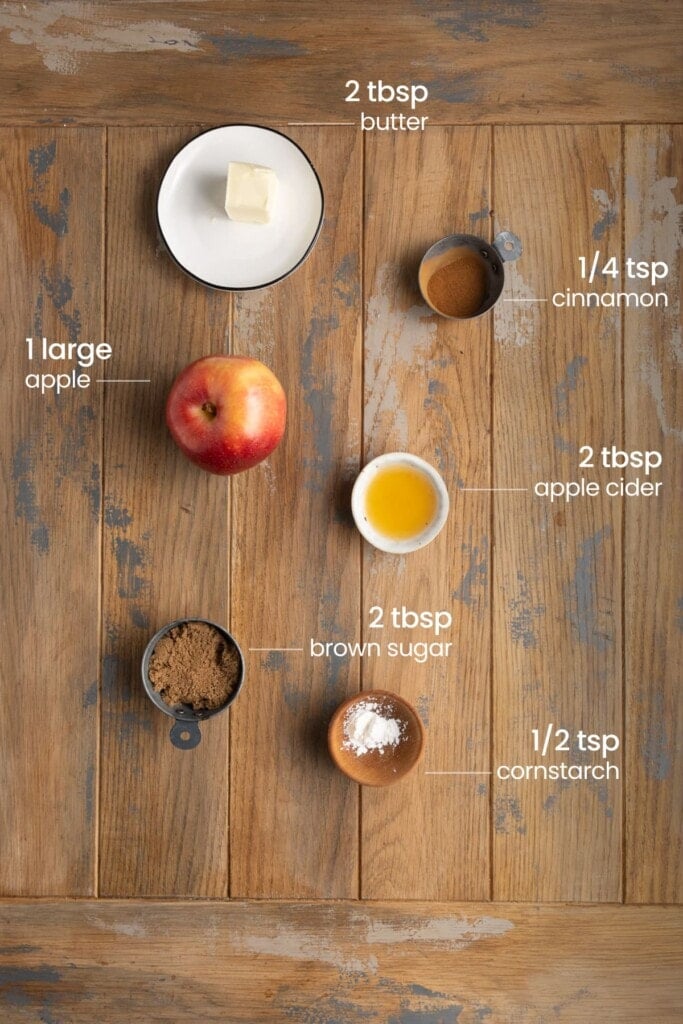 All ingredients needed for sautéed apples including butter, cinnamon, apple, apple cider, brown sugar, and cornstarch.