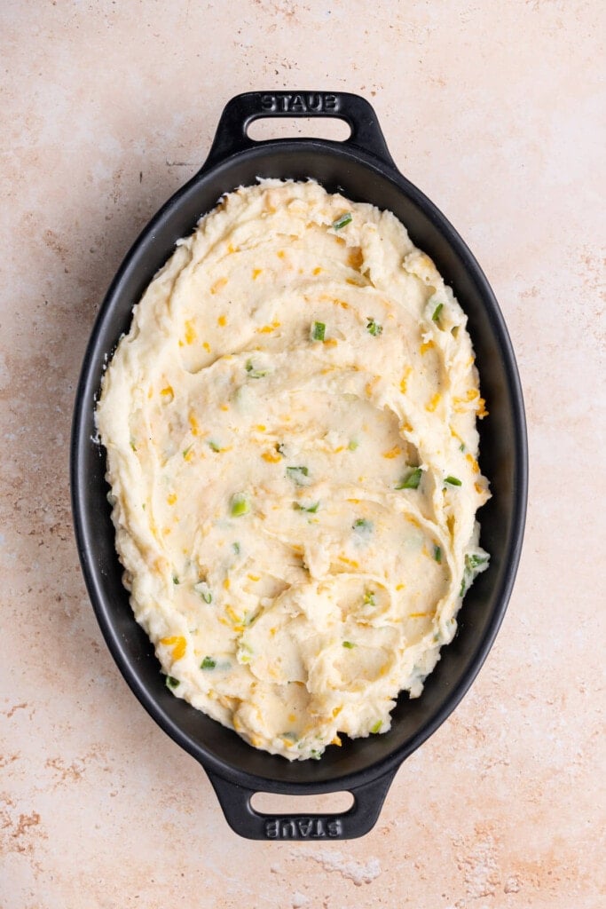 Mashed Potatoes with cheddar cheese and scallions in a casserole dish. 