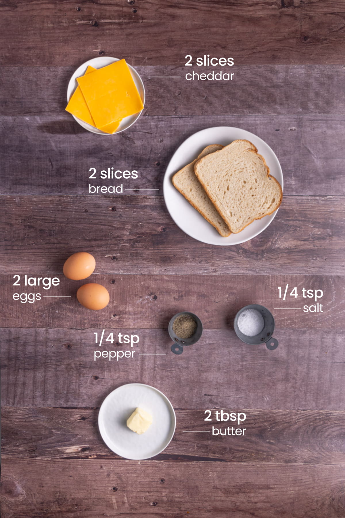 all ingredients for scrambled egg and cheese sandwich - cheddar cheese, bread, eggs, pepper, salt, butter