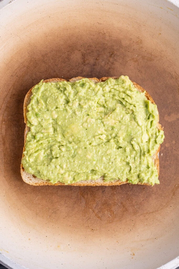 Bread with smashed avocado frying in a hot pan with butter. 