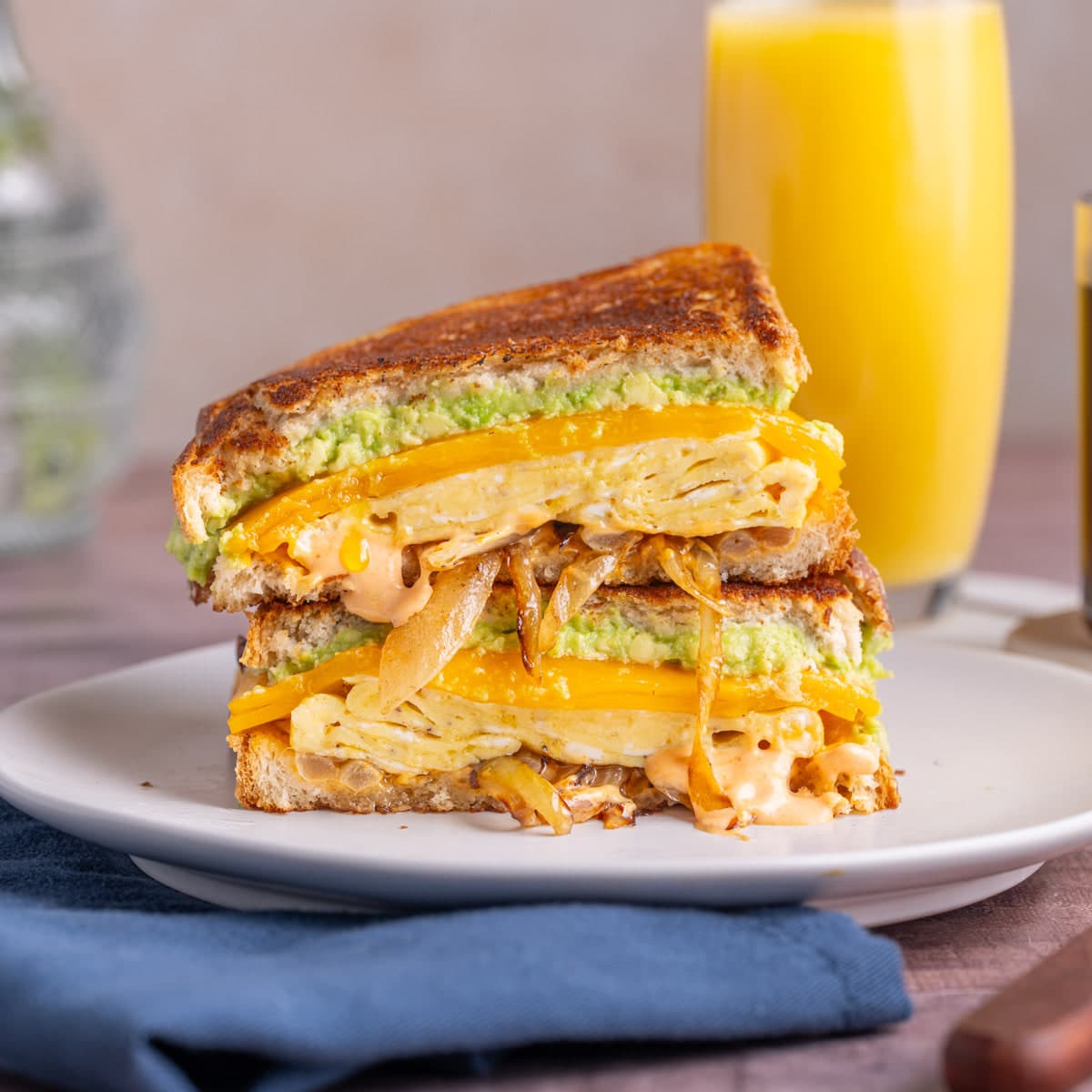 Epic breakfast sandwich sliced in half and stacked on a plate.