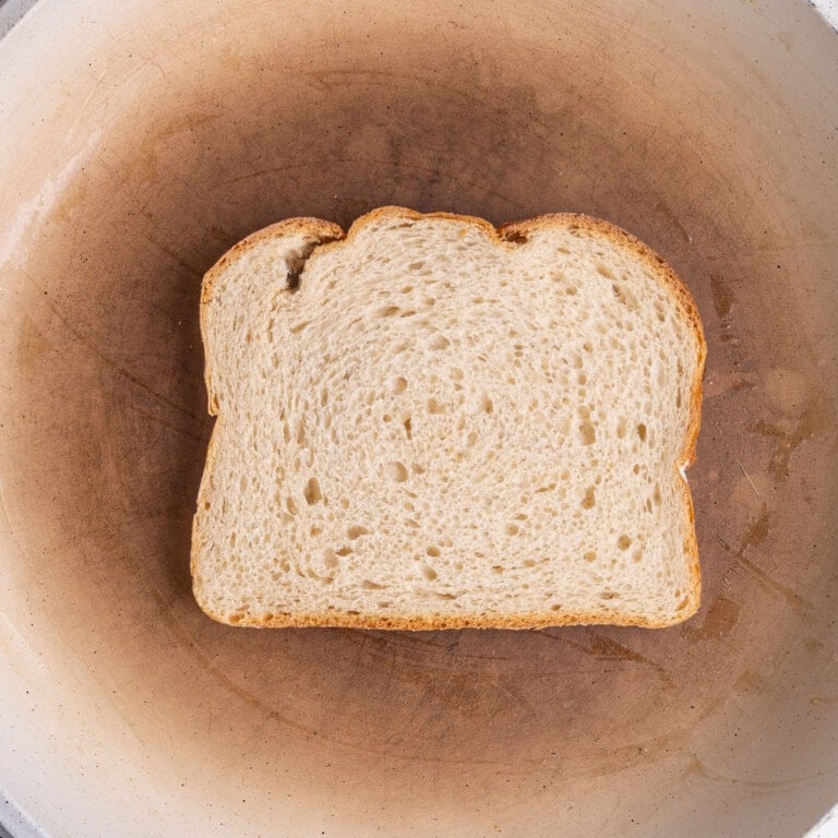 Buttered bread frying in a pan over medium heat.