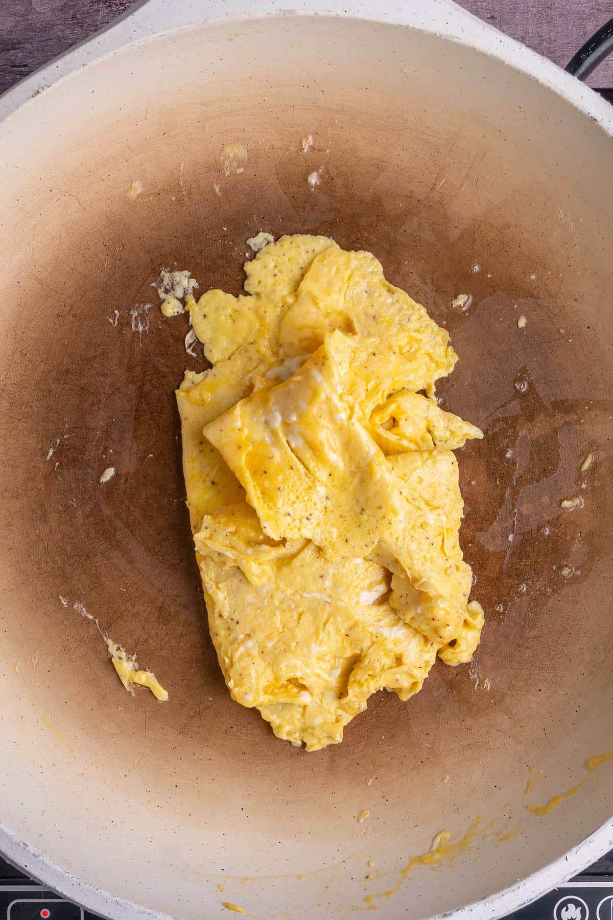 Forming scrambled eggs into a shape that is roughly the same as a slice of bread so that they fit nicely into a breakfast sandwich. 