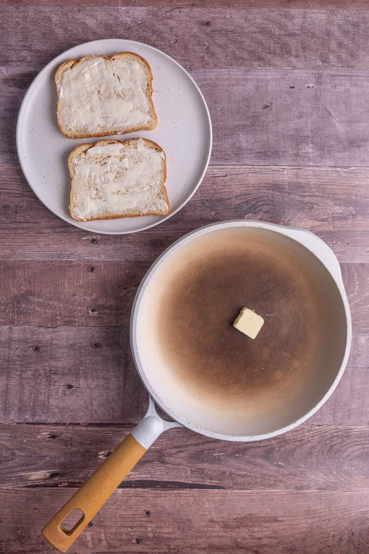 Using two tablespoons of butter to spread across two slices of bread and one tablespoon of butter to coat a frying pan. 