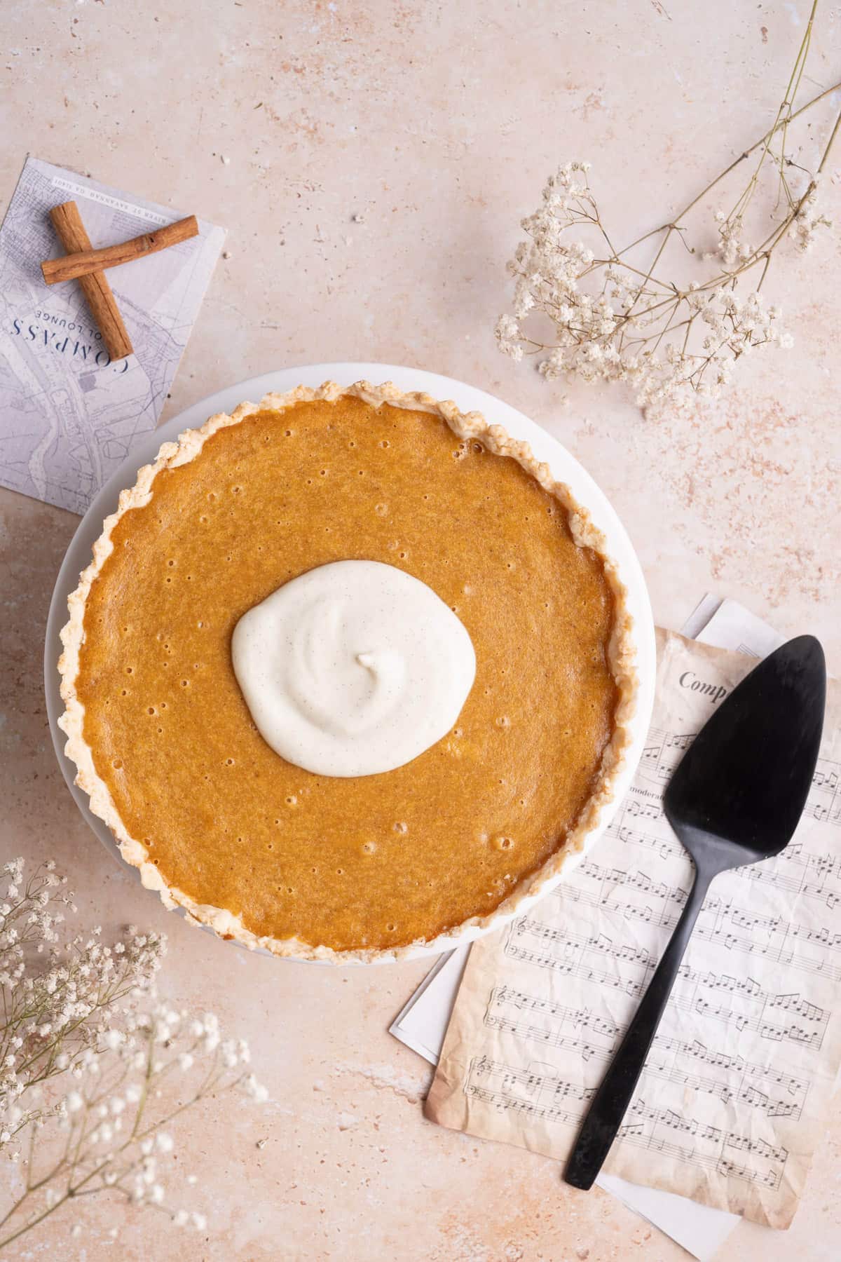 Whole sweet potato pie with whipped topping in the center.
