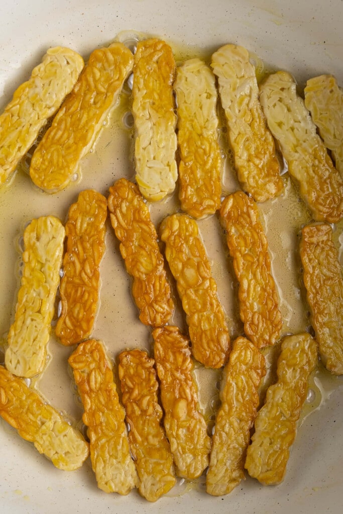 Flipping tempeh to cook on second side. 