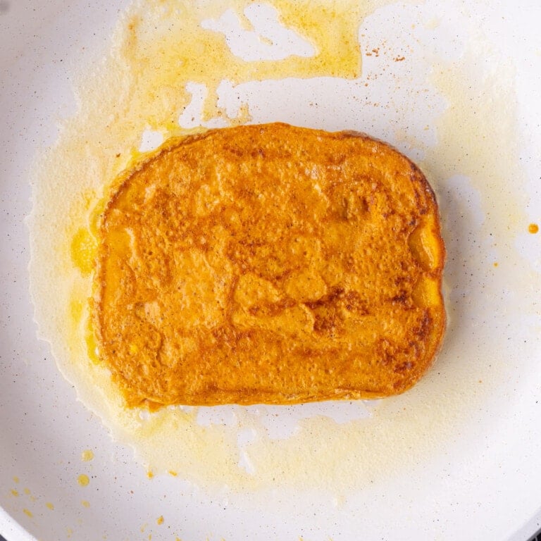 Frying pumpkin French toast in a pan over medium heat.