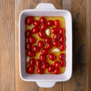 Grape tomatoes and whole garlic cloves submerged in olive oil mixed with honey and sea salt.