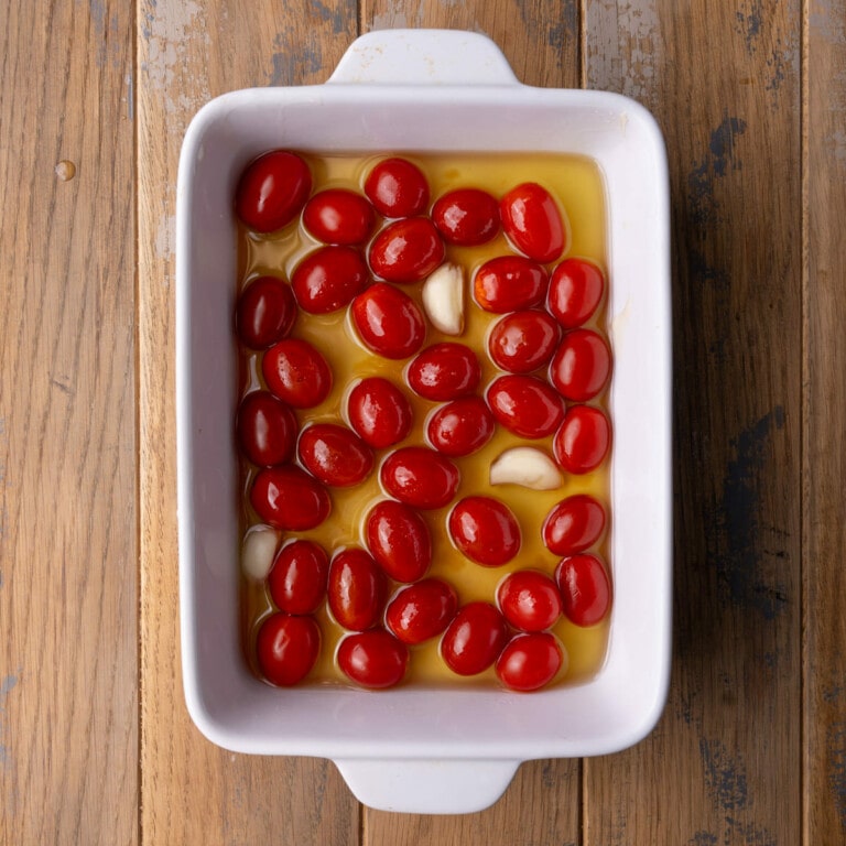 Grape tomatoes and whole garlic cloves submerged in olive oil mixed with honey and sea salt.