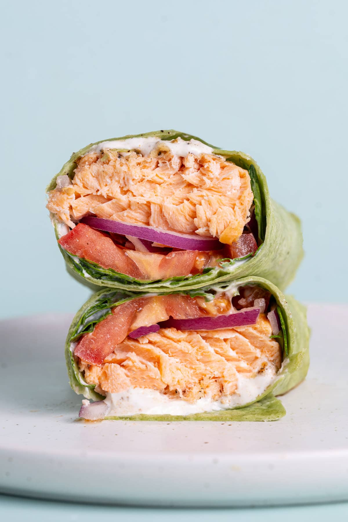 Hot Salmon Wrap with Greek Yogurt sliced in half and stacked atop one another. 