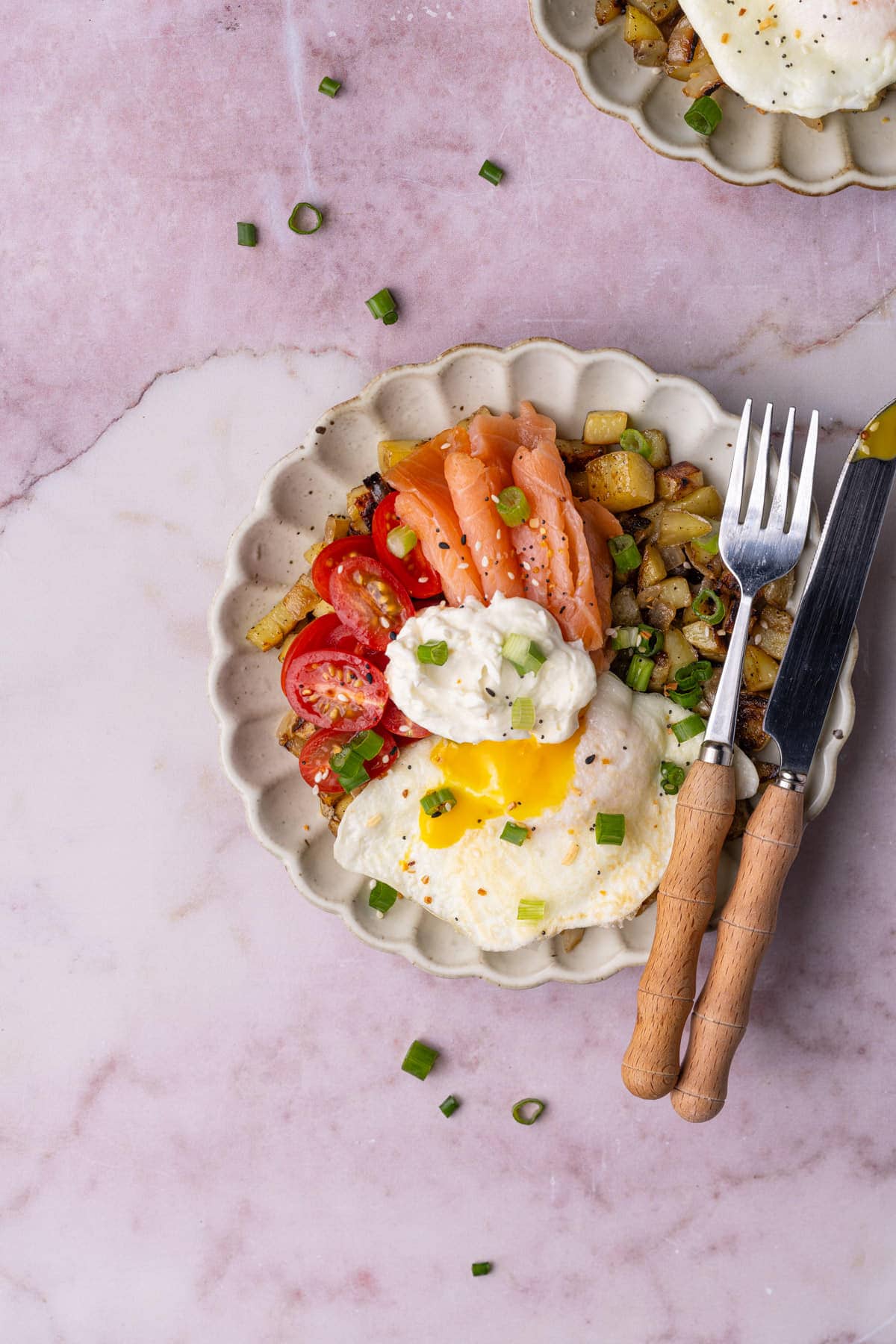 Overhead image of smoked salmon breakfast bowl with a fork and knife. 