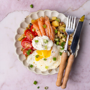 Smoked salmon breakfast bowl with tomatoes and a fried egg.