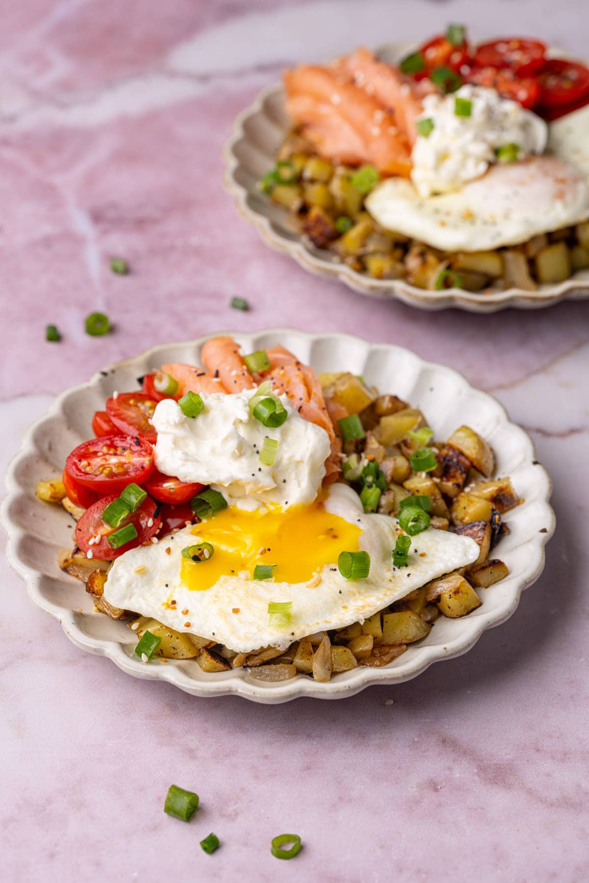 Two smoked salmon breakfast bowls garnished with scallions. 