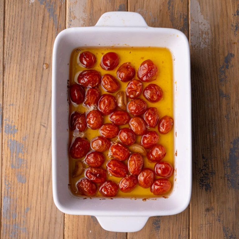 Grape tomatoes and garlic cloves slow roasted in olive oil with honey and salt.