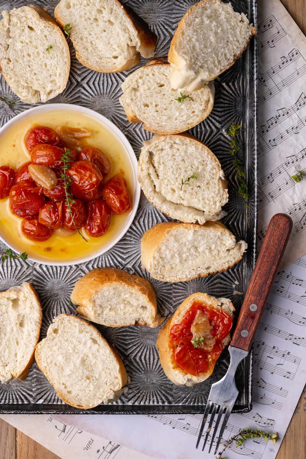 Close up crop of tomato confit served with sliced French baguette.