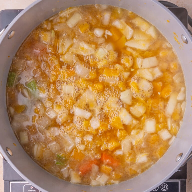 Vegetables simmering in a combination of vegetable broth and apple juice.