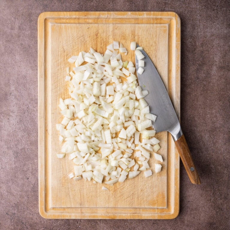 Two yellow onions cut around the core, peeled, and diced.
