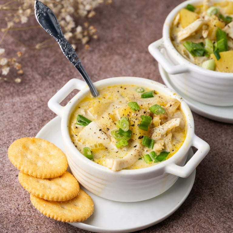 Creamy halibut chowder served with crackers and garnished with scallions.