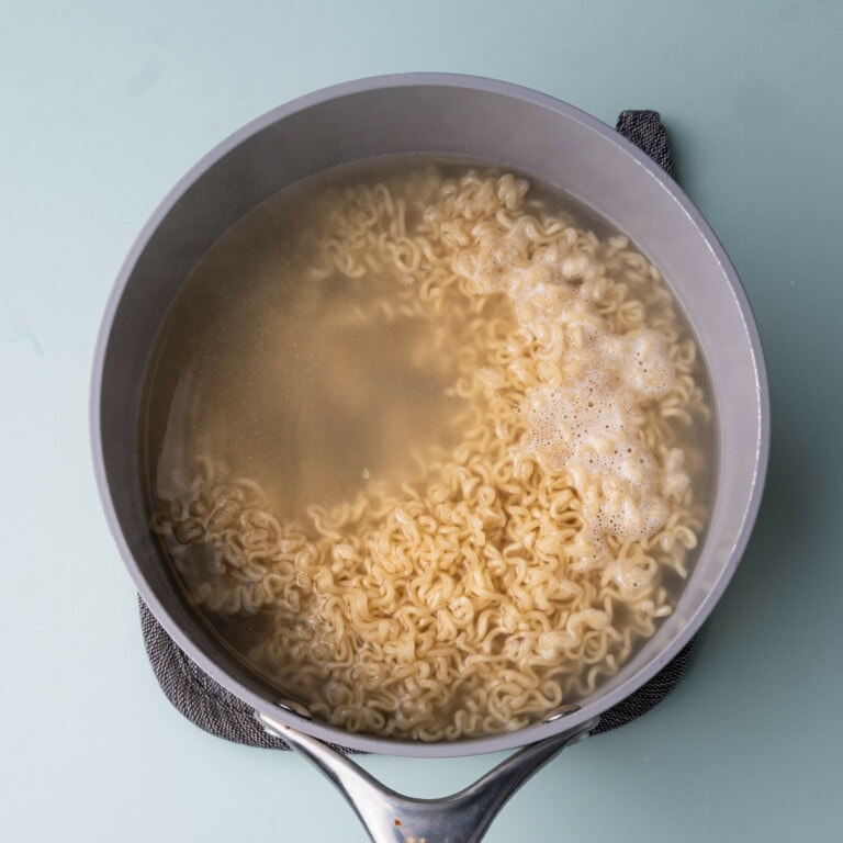 Ramen noodles boiling for 3 minutes in a saucepan with water.