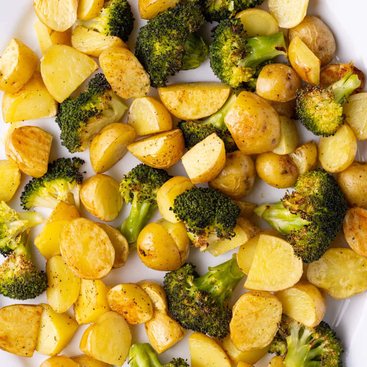 Golden brown honey gold potatoes and crispy roasted broccoli on a serving platter.
