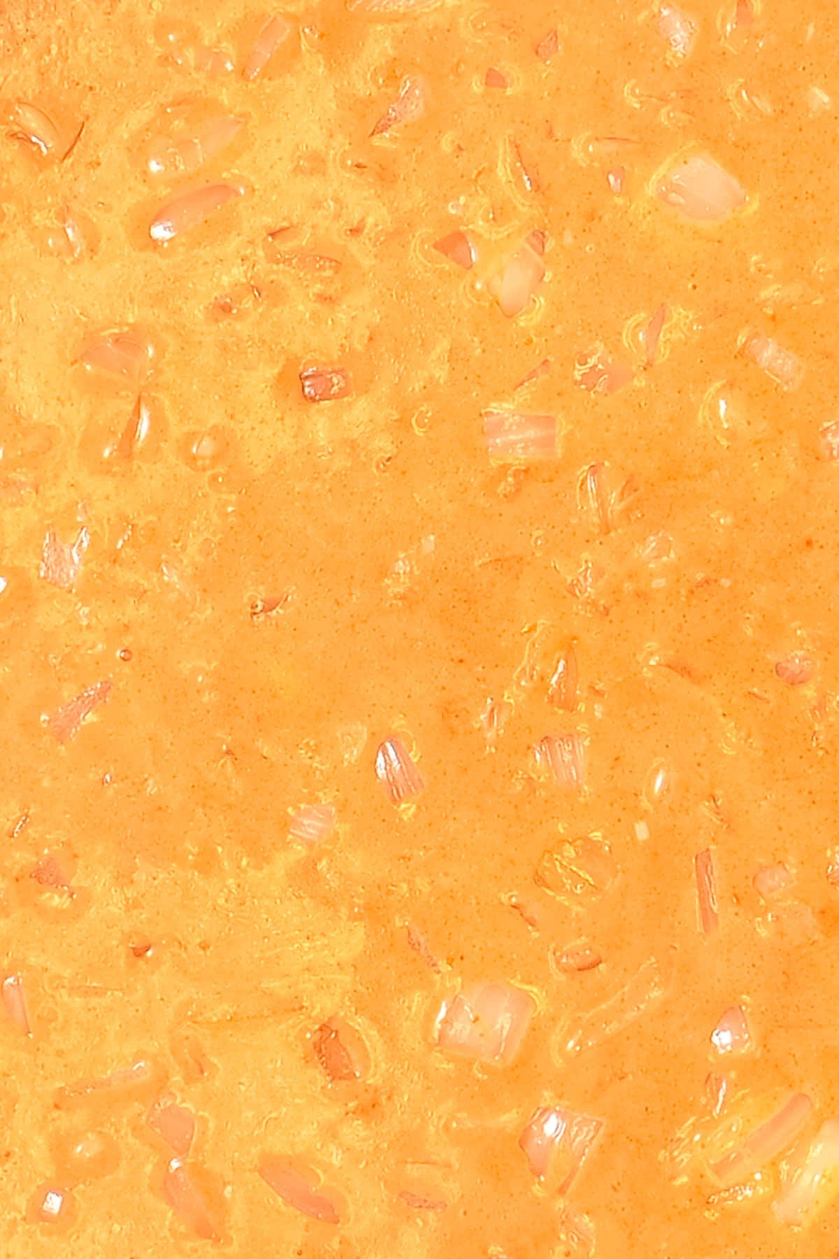 Close up of coconut curry sauce before adding salmon and spinach. 