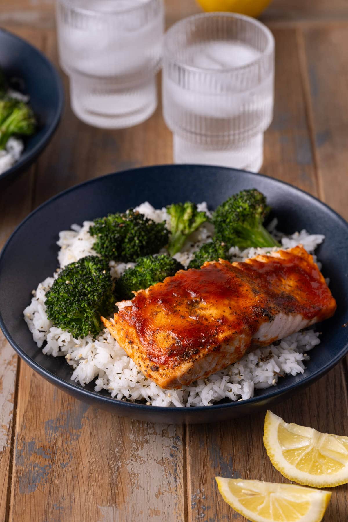 Honey sriracha salmon served with broccoli over a bed of rice.