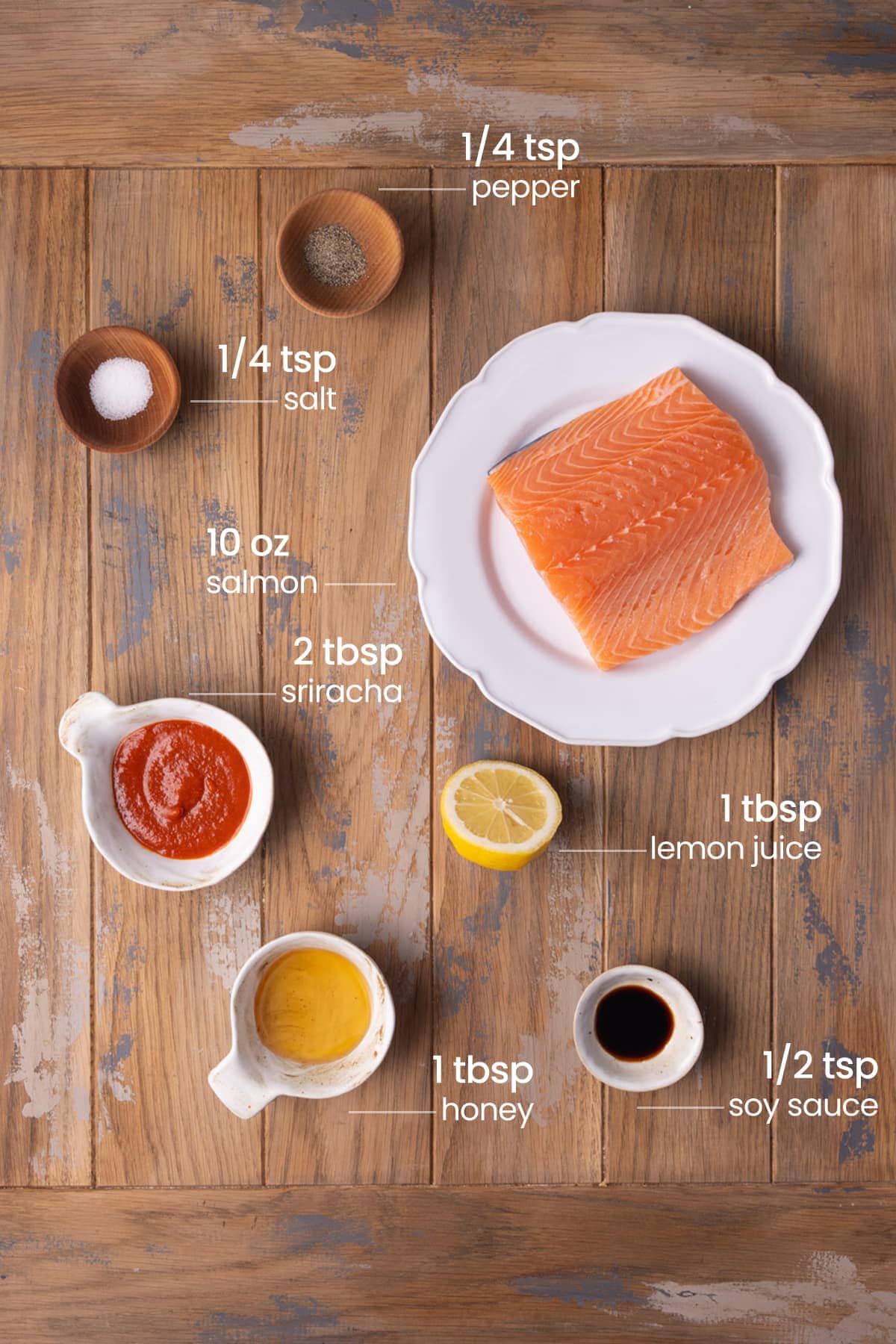 all ingredients for honey sriracha salmon - pepper, salt, salmon, sriracha, lemon juice, honey, soy sauce