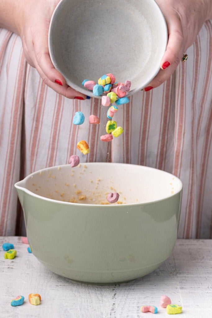 Adding Lucky Charms marshmallows to cookie dough.