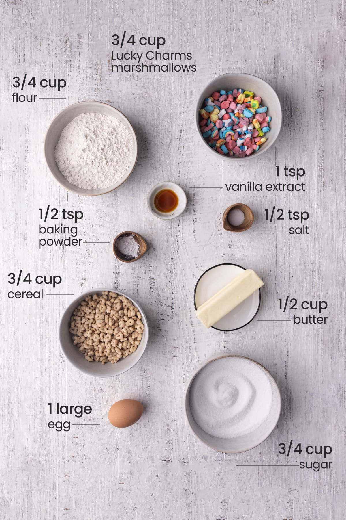 all ingredients for Lucky Charms cookies, including flour, Lucky Charms marshmallows, vanilla extract, baking powder, salt, Lucky Charms cereal, butter, egg, sugar