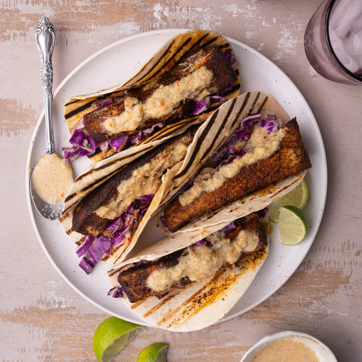 Plate of Mahi-mahi tacos with a spoonful of Baja sauce.
