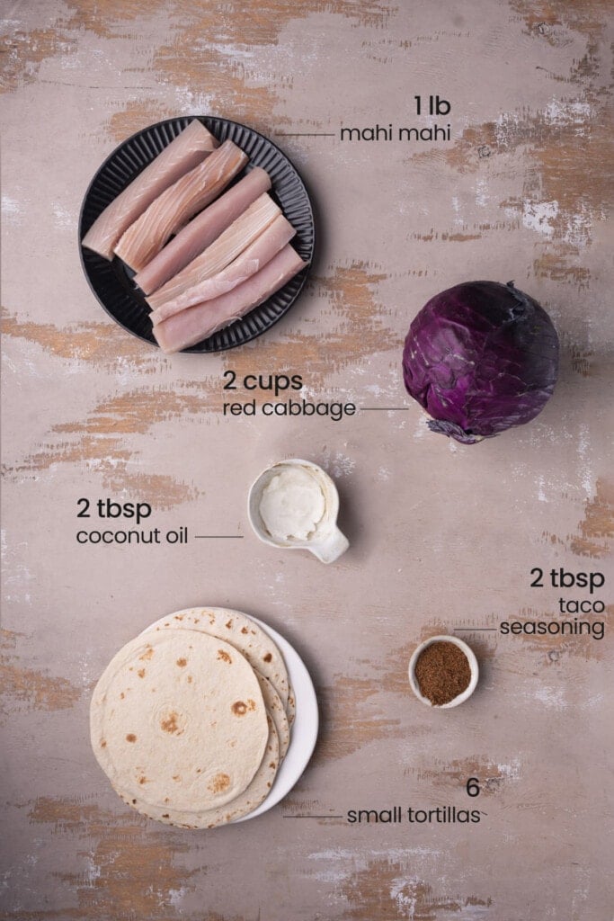 Ingredients for mahi-mahi tacos, including mahi-mahi, taco seasoning, tortillas, red cabbage, and coconut oil.