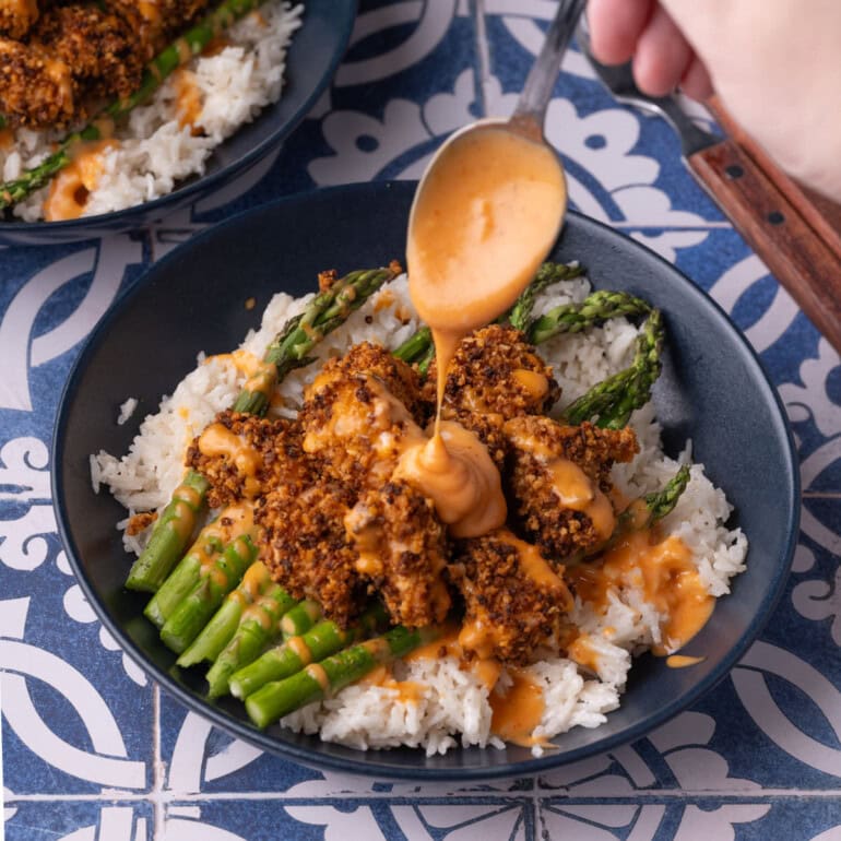 Drizzling extra bang bang sauce over crispy salmon bites.