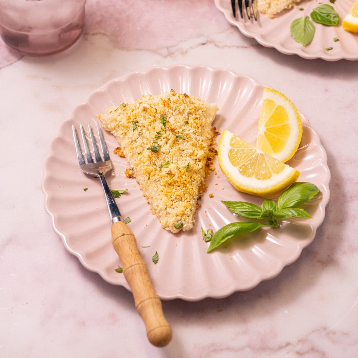 Crispy cod with panko crust served with lemon wedges.