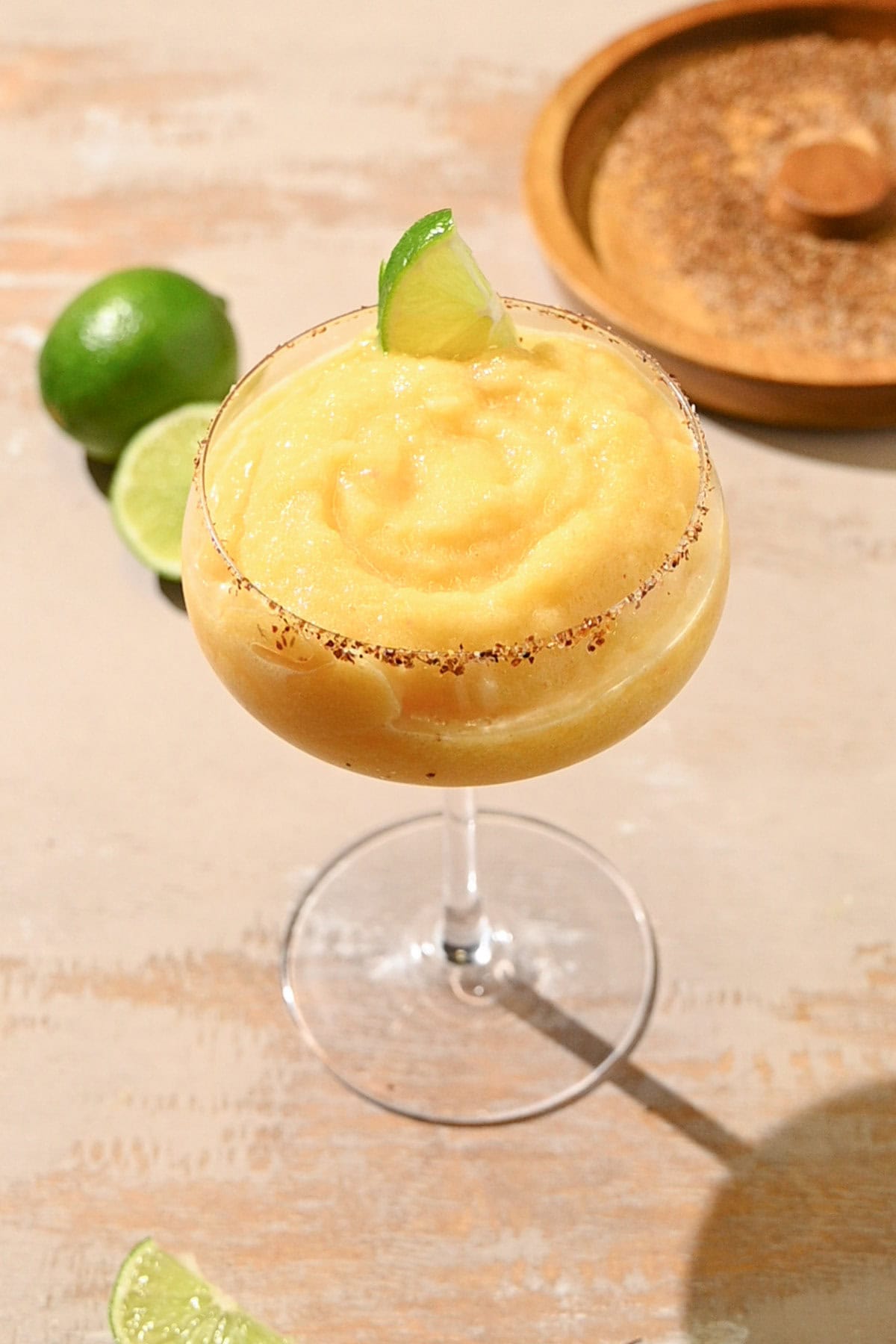 Frozen Peach Margarita garnished with a lime wedge. 