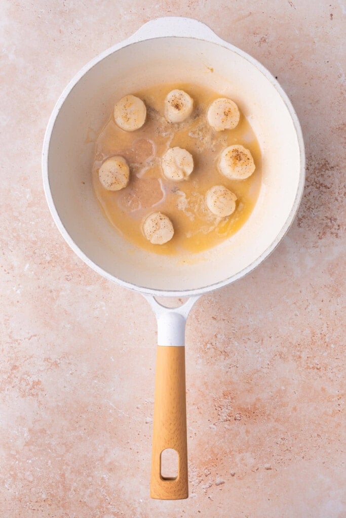 Searing sea scallops in butter, salt, pepper, and lemon juice.