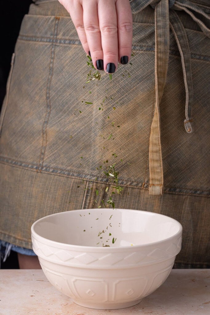 Making a shrimp marinade out of fresh herbs, garlic, oil, and vinegar. 