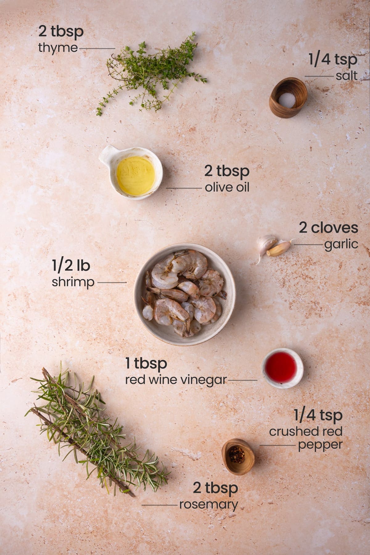Overhead image of ingredients for herby shrimp polenta - thyme, salt, olive oil, garlic, shrimp, red wine vinegar, crushed red pepper, and rosemary.