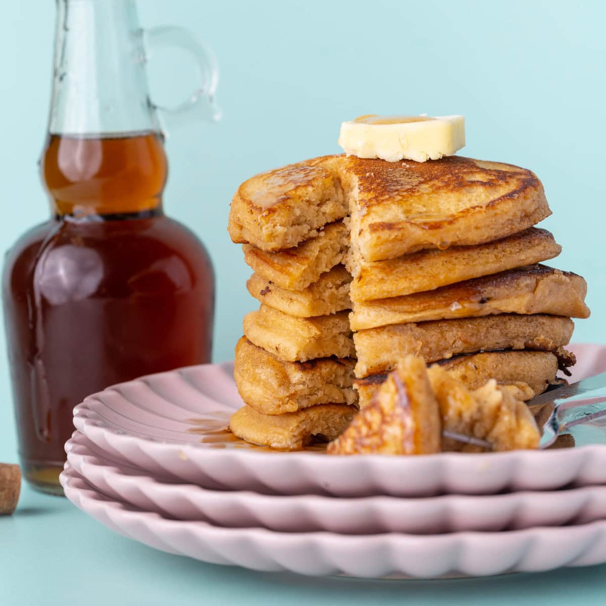 Stack of pancakes with maple syrup with bite cut out