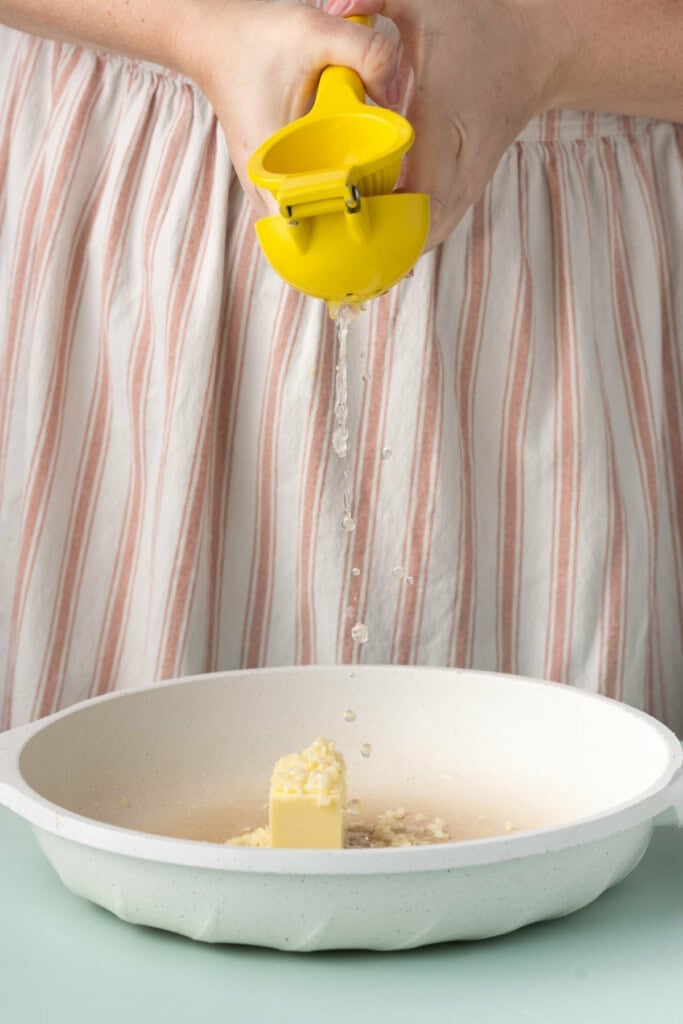 Adding lemon juice to pan with butter, garlic, and Old Bay.