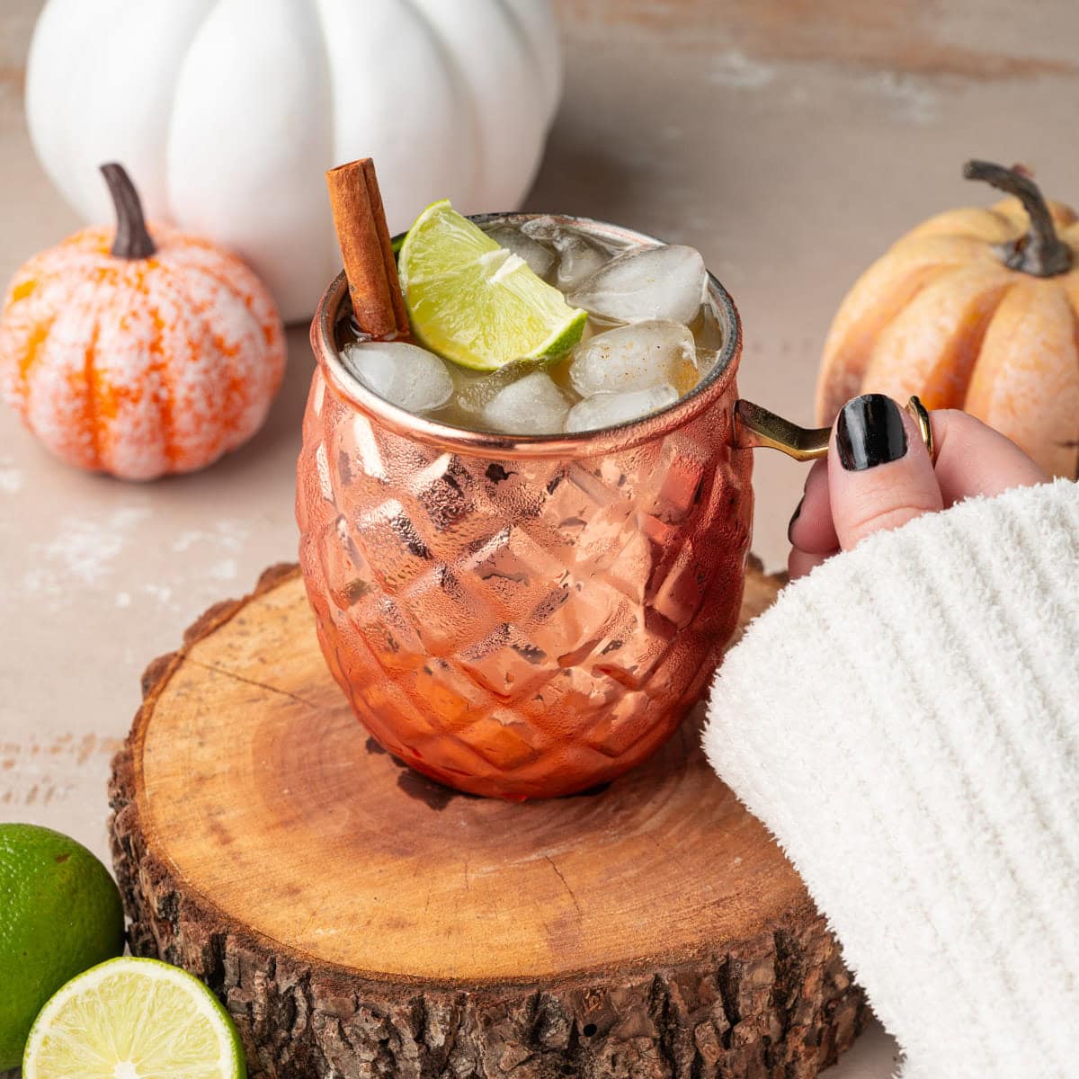 Grabbing a copper mug filled with a Fall-spiced mule.