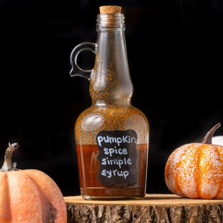 Sealed jar of pumpkin spice simple syrup on a wooden stand.