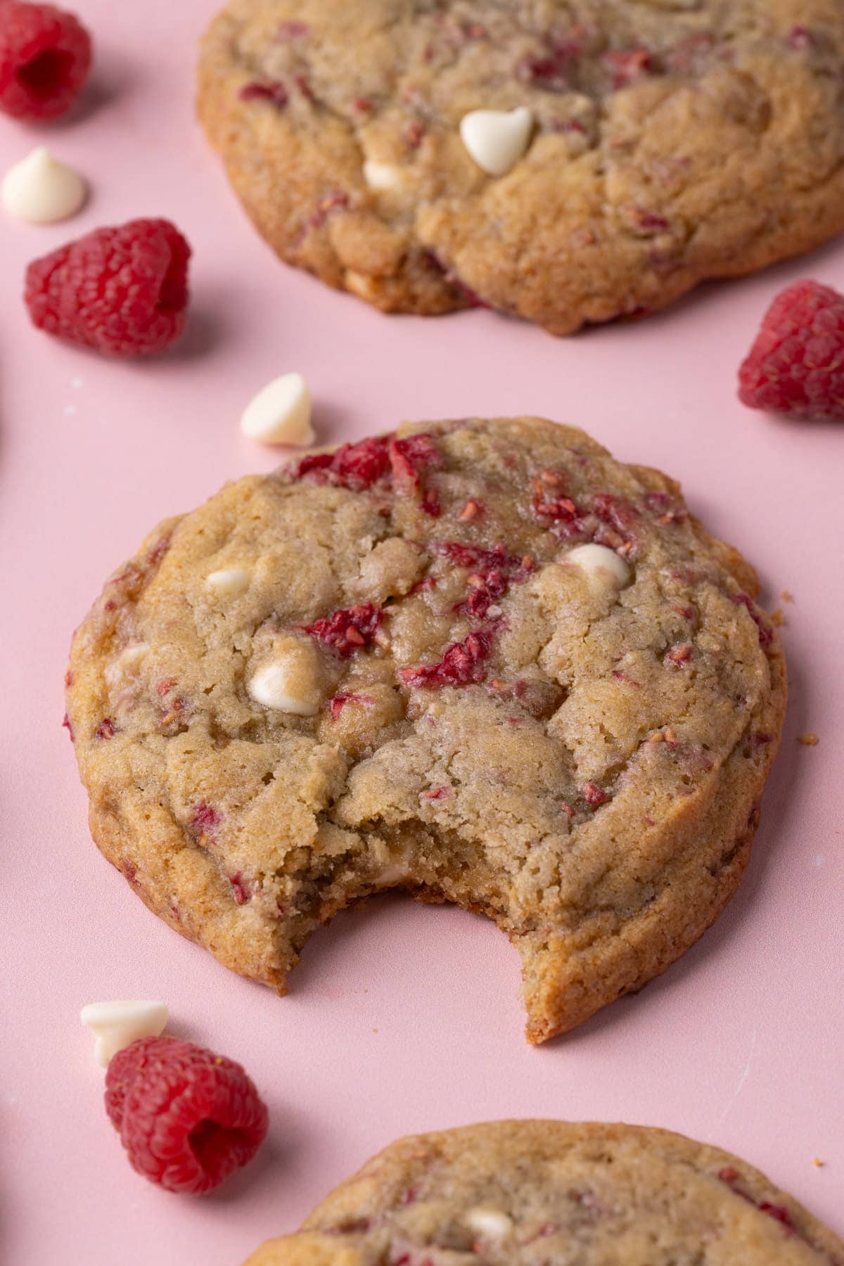 Raspberry and white chocolate cookies with center one having a big bite taken out of it. 