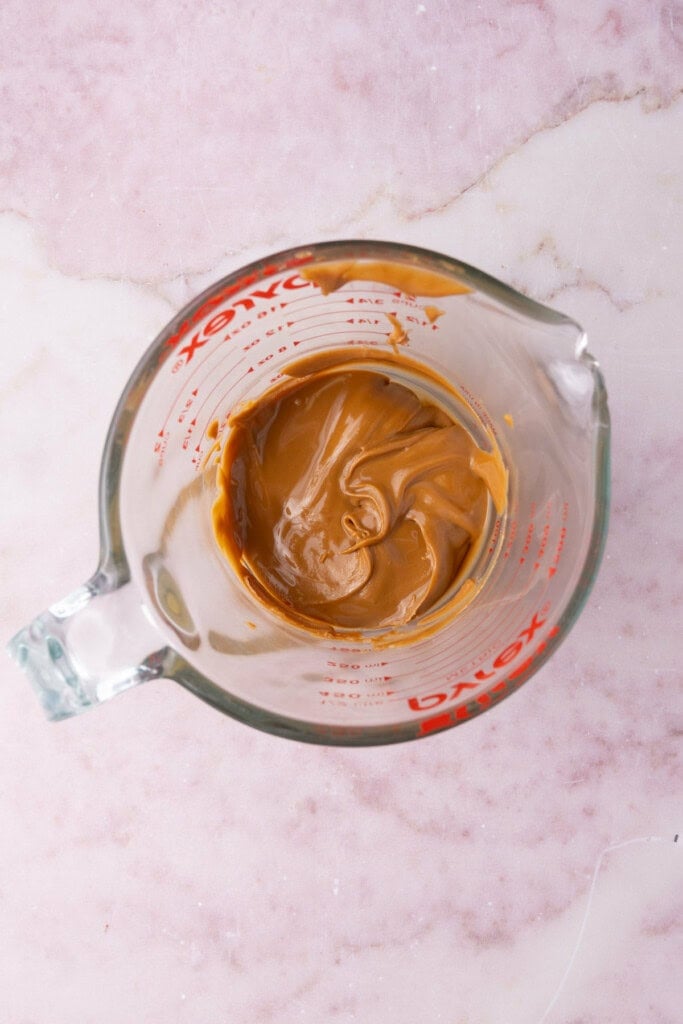Biscoff cookie butter in a measuring cup heated up in the microwave to make it easier to pour.