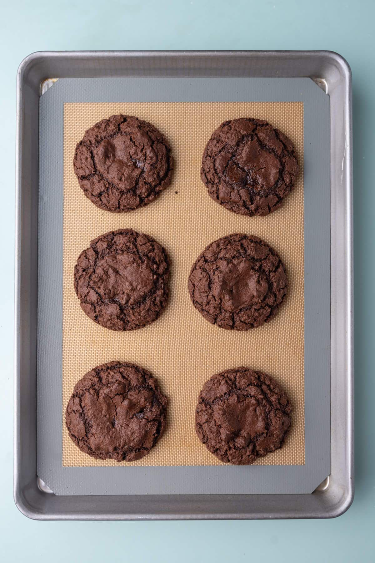 Chocolate fudge cookies fresh out of the oven still on the baking tray. 
