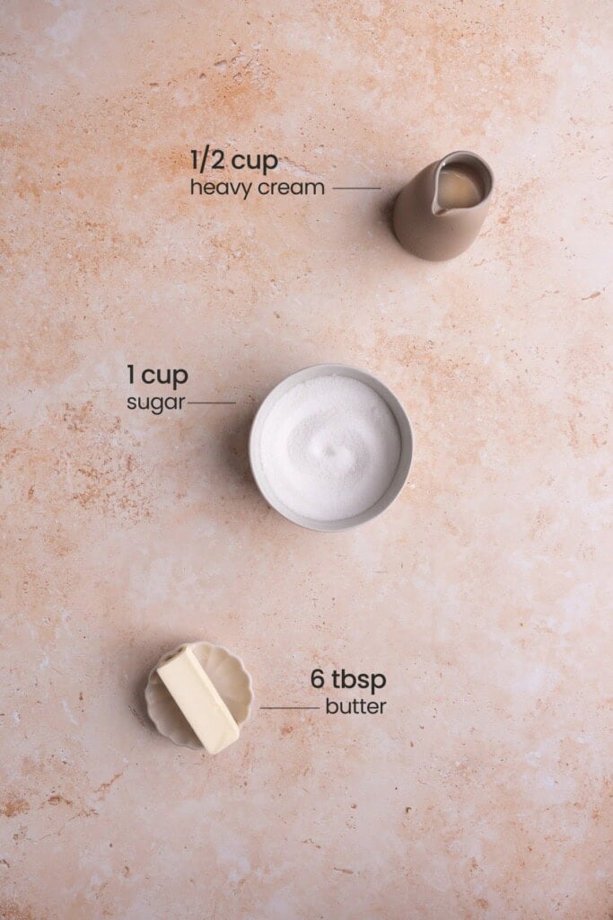 Overhead view of all the ingredients needed for salted caramel sauce - heavy cream, sugar, and salted butter.
