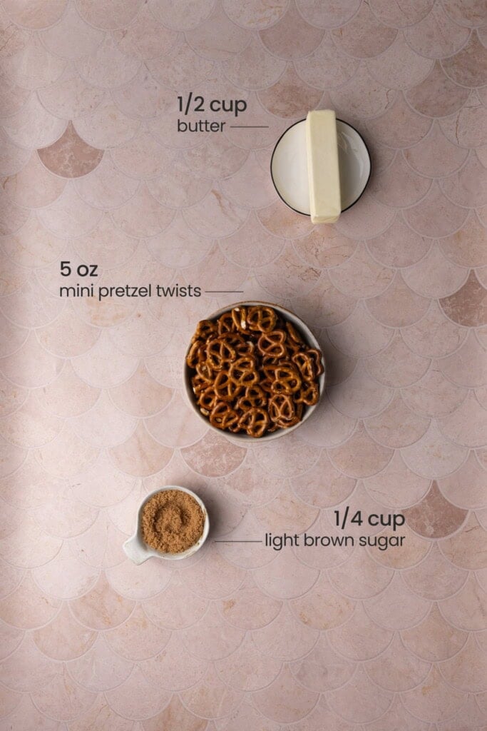 Overhead view of the ingredients needed for the crust of a pretzel brownie - butter, mini pretzels, and light brown sugar.