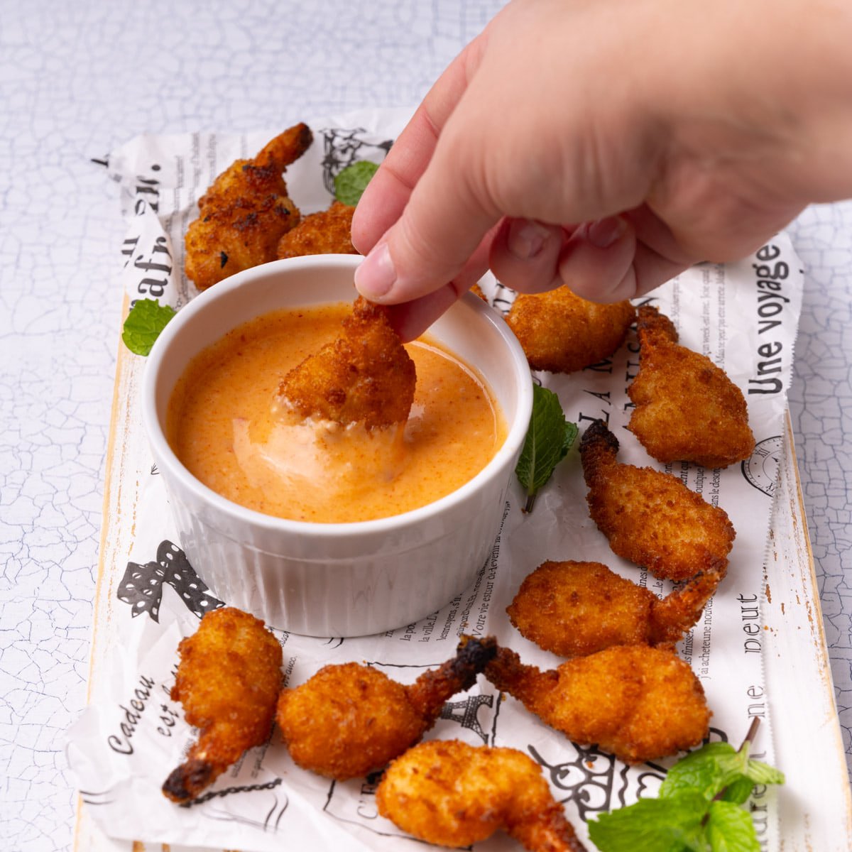 Dipping butterfly shrimp into homemade Bang Bang sauce.