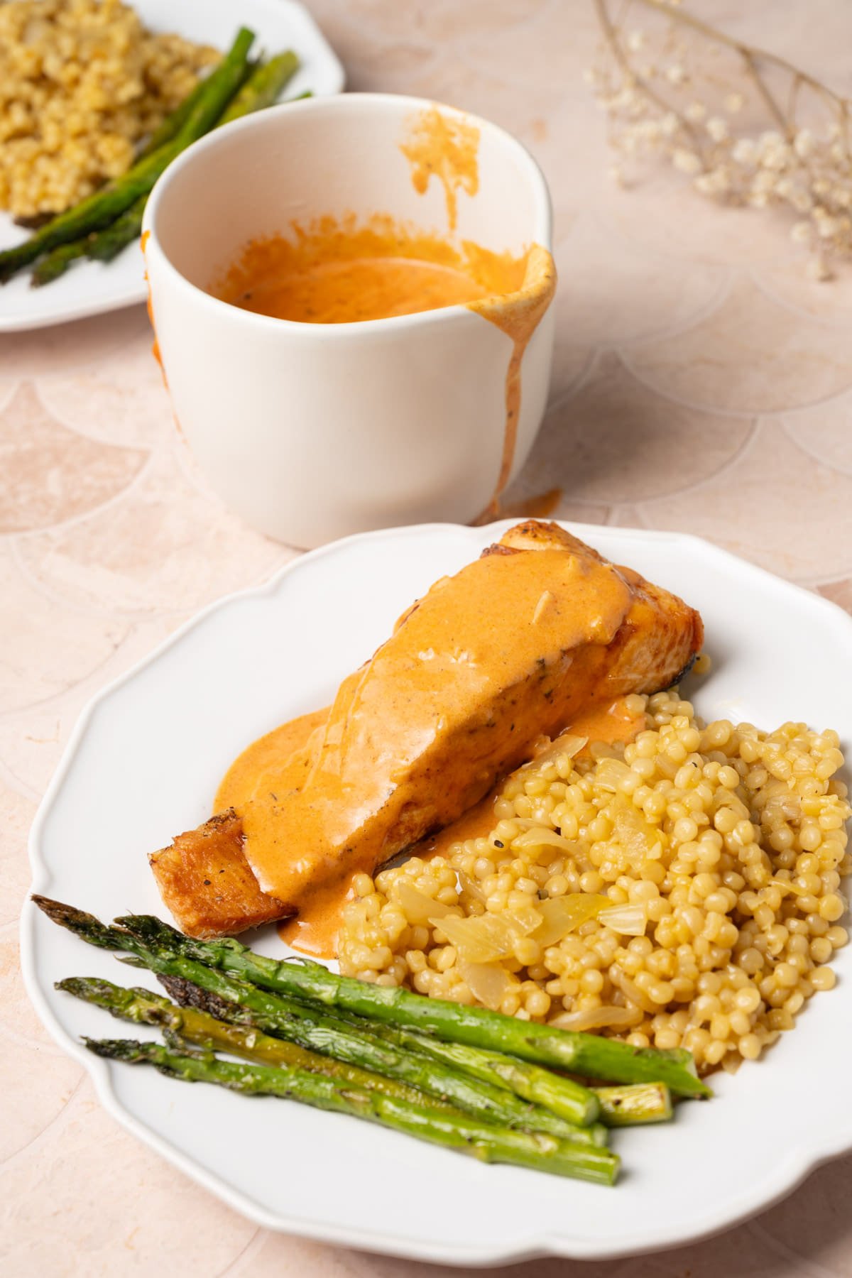 Cajun cream sauce served over a dinner plate with extra sauce in the background. 