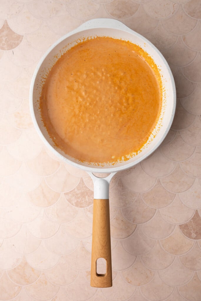 Butter, garlic., tomato, paste, cream, and Cajun seasoning all thickening in a pan. 