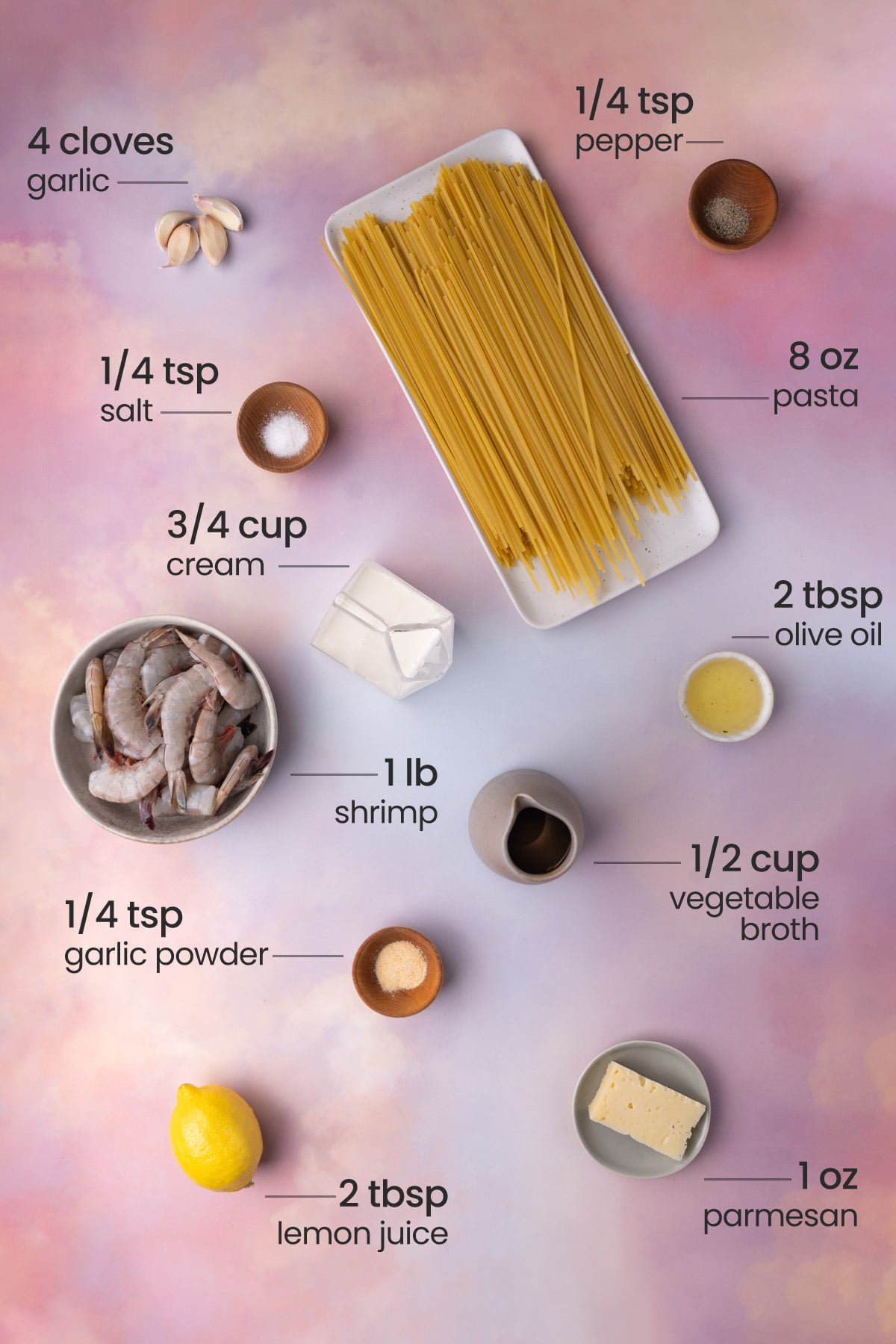 Overhead view of all the ingredients for Creamy Garlic Shrimp Pasta - garlic, pepper, salt, cream, shrimp, garlic powder, pasta, olive oil, vegetable broth, and lemon juice.